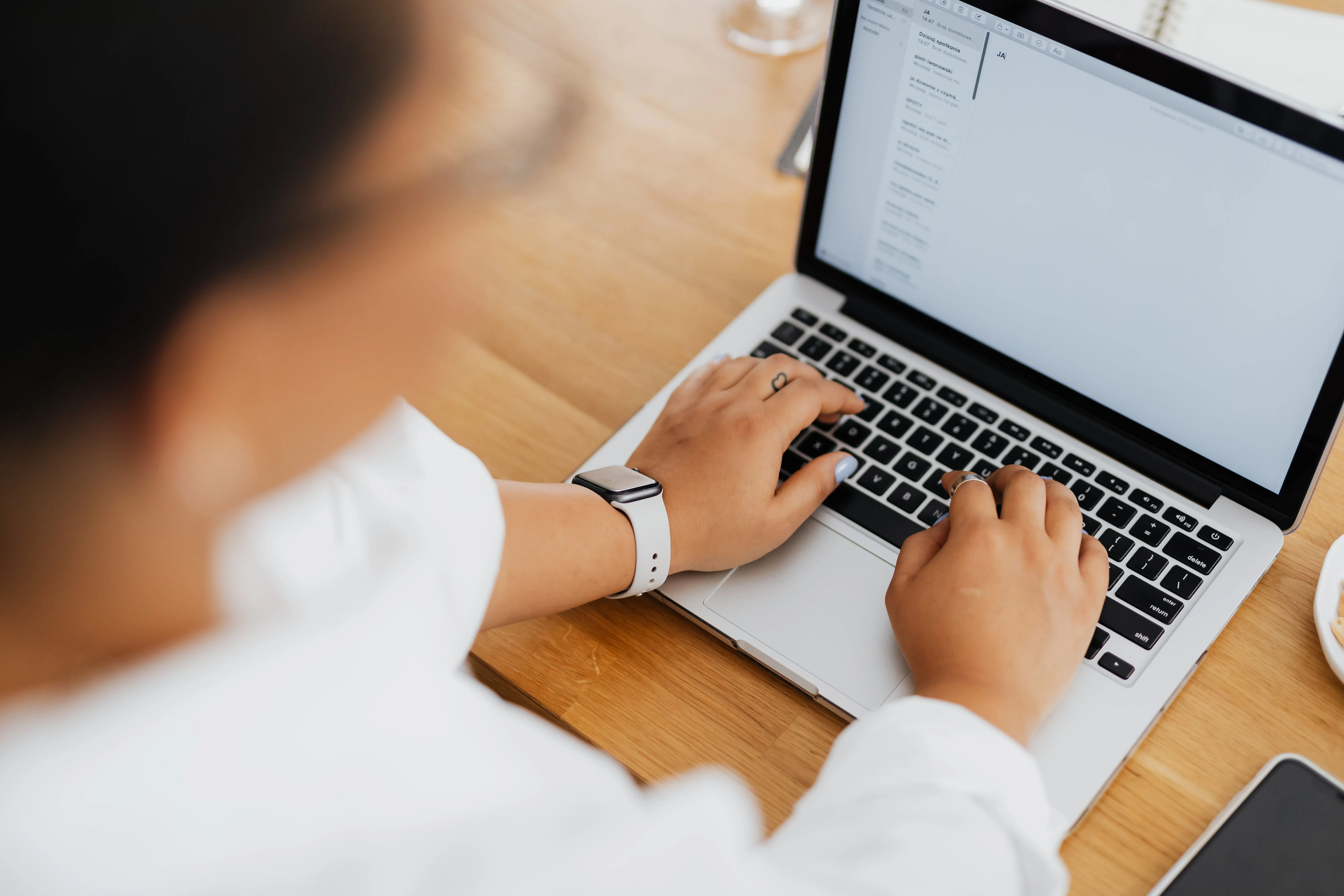 Person typing on a laptop keyboard, capturing new newsletter subscribers from a landing page