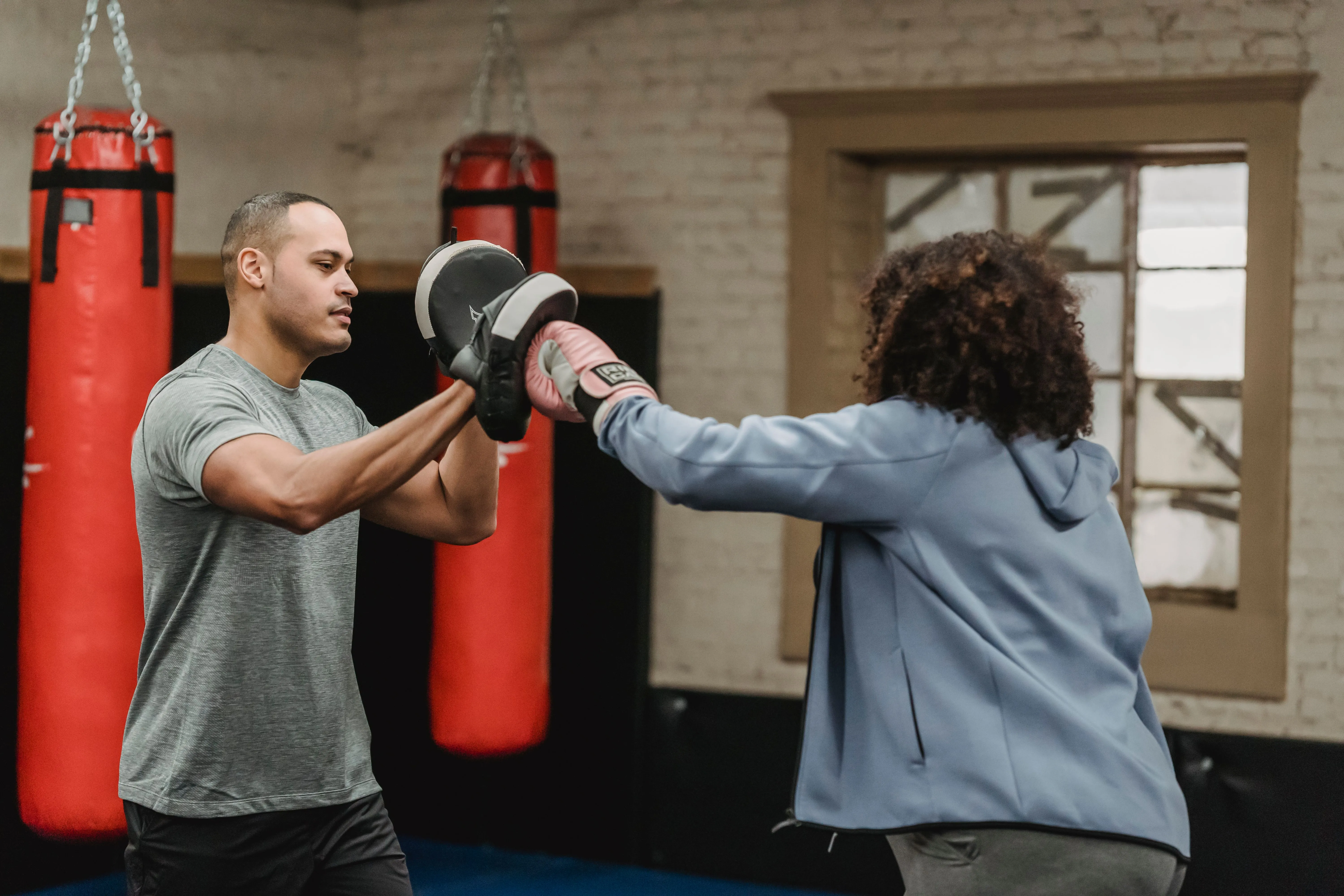 A coach running punch mitts with a member, the raw material for almost every post worth making
