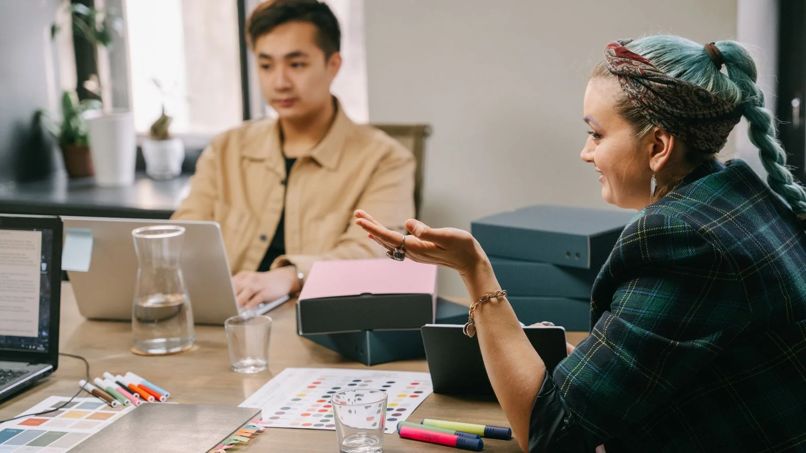 Two coworkers in a strategy meeting at a desk, mapping a new service offering