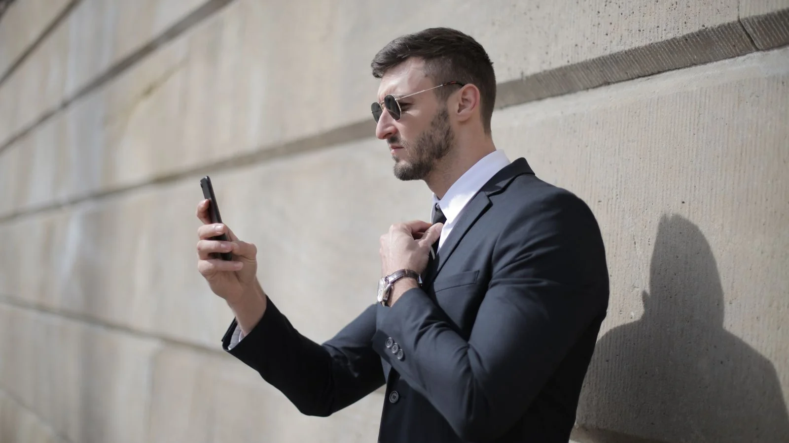 A person checking their phone on the street, the moment a constraint-shaped question gets asked and answered