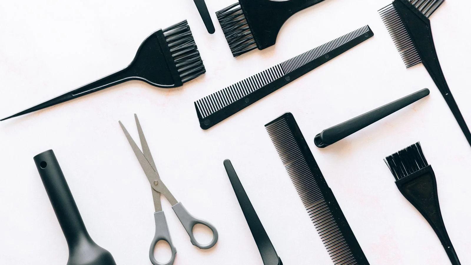 A flat lay of brushes, combs and scissors, the service detail that has to exist as text before an assistant can cite it