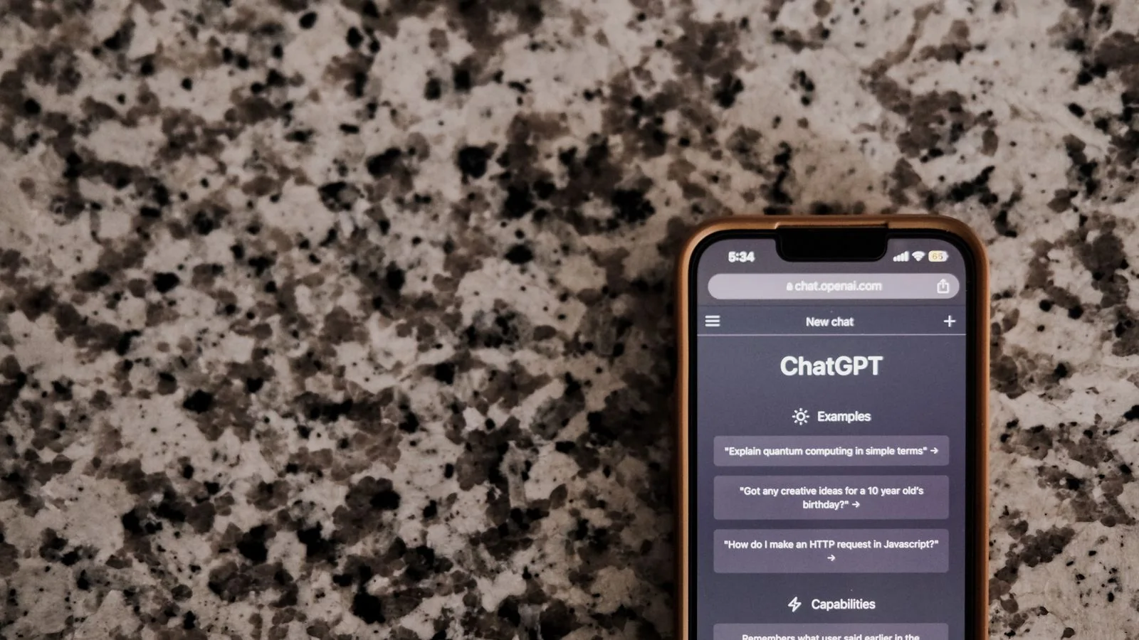 A smartphone showing a ChatGPT conversation resting on a speckled surface