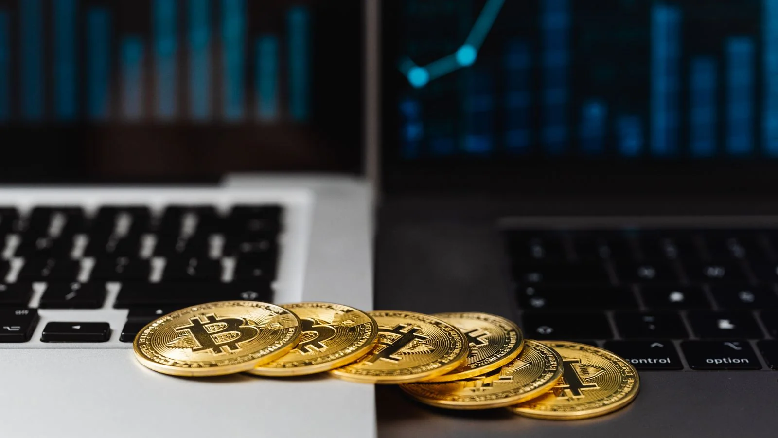 Gold coins on a laptop displaying financial graphs, the setup behind a crypto buyer's research