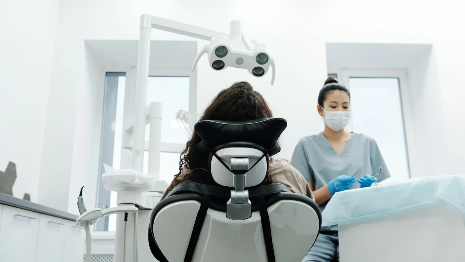 Dentist examining a patient in a modern clinic, the real-world care an AI can only infer from your online signals