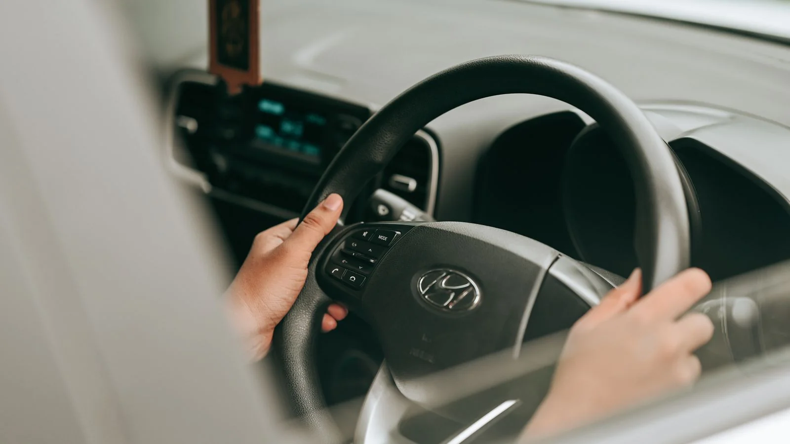 Hands on a steering wheel from the passenger side view, the detail every learner is anxious about