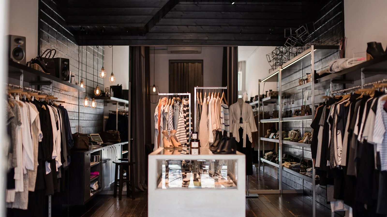 A clean, modern fashion retail store interior with organized clothing displays.