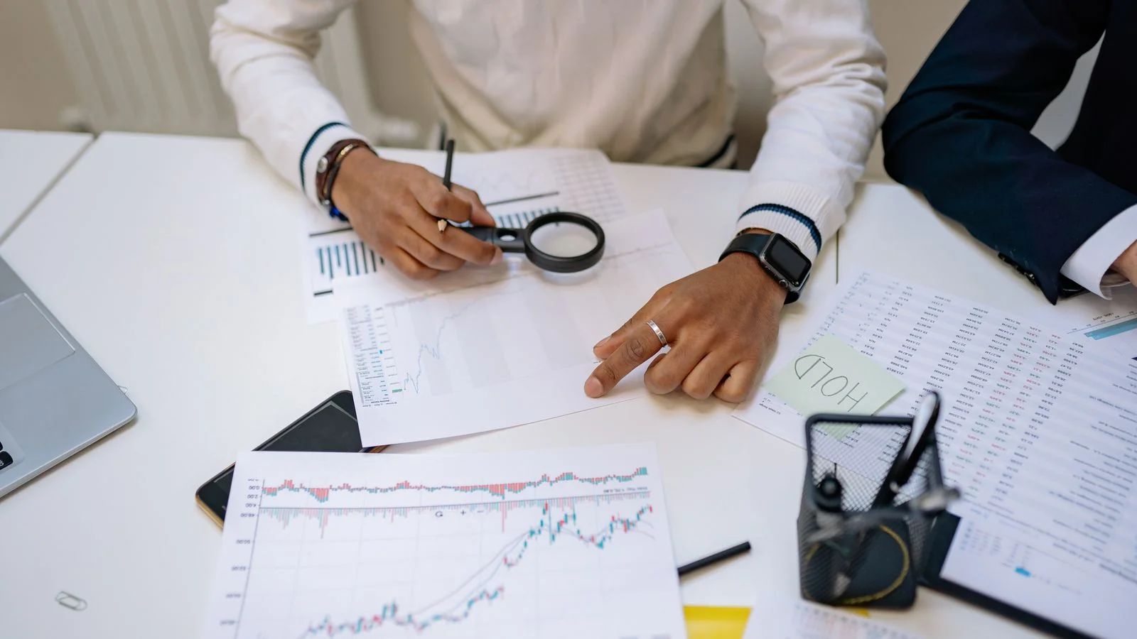 Advisors reviewing charts with a magnifying glass during a client portfolio audit