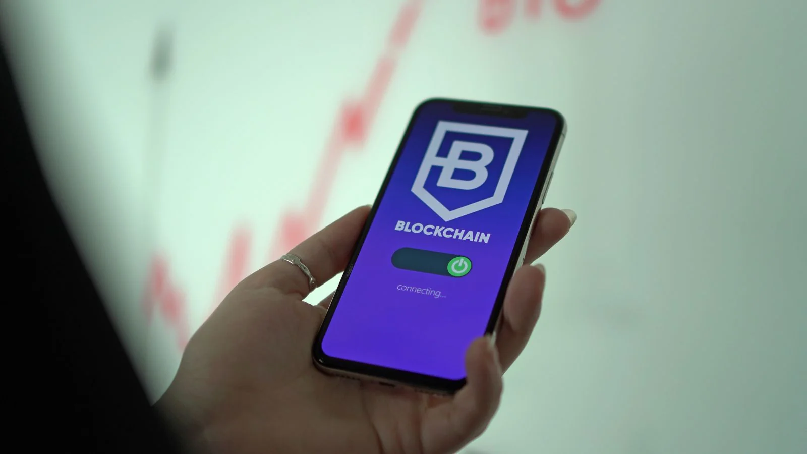 A hand holding a smartphone displaying a cryptocurrency wallet app
