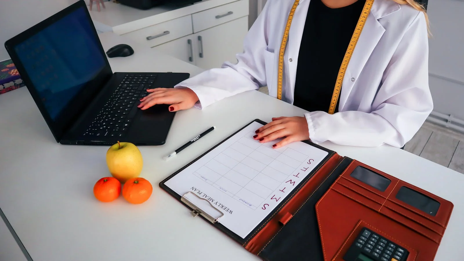 A nutrition consultation in progress with meal plan paperwork and fresh produce, the kind of specific wellness expertise that earns press features and AEO citation lift.
