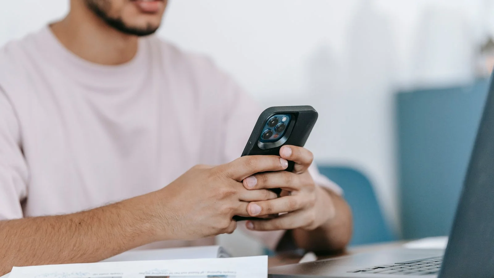 A man comparing flooring options on his phone and laptop at the same time.
