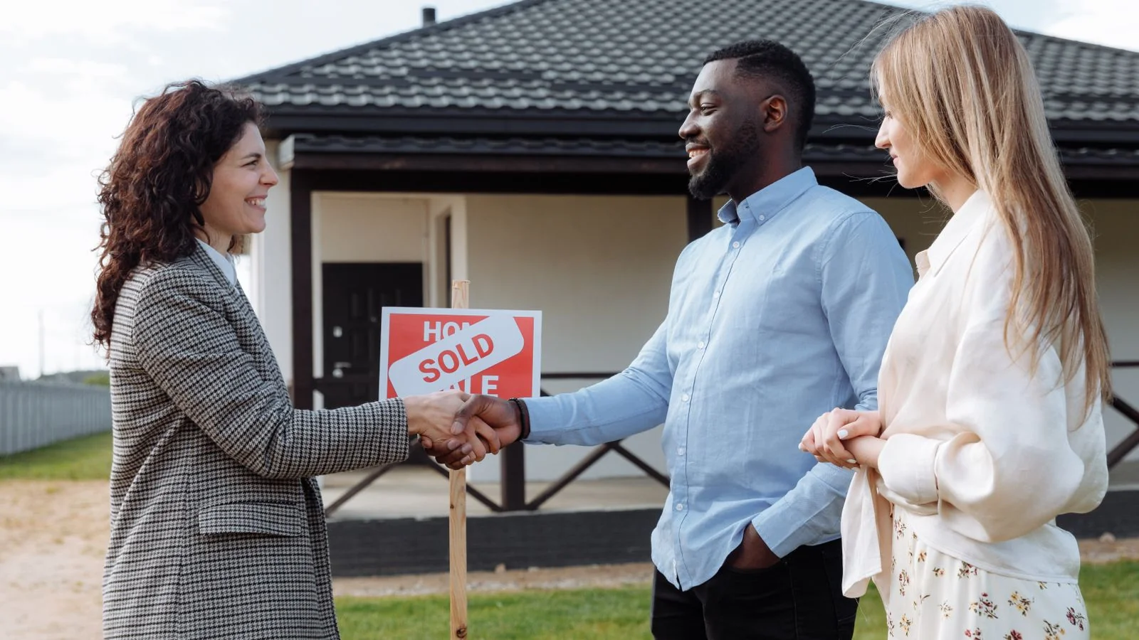 An advisor sealing an agreement with a couple outside their home, the trust an insulation buyer looks for.