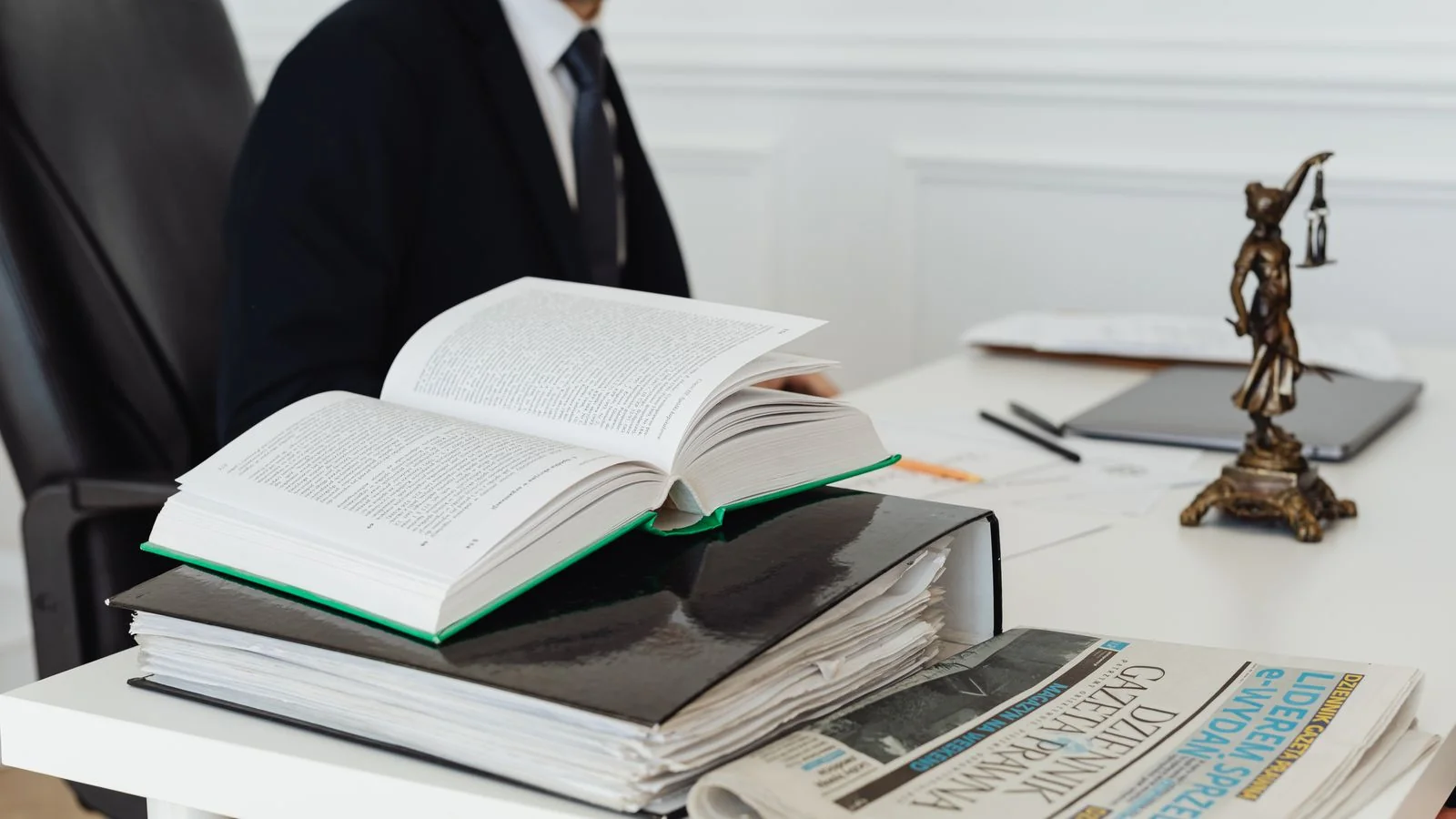 Lawyer's desk with legal books, documents, and a newspaper, the source material AI answers draw from