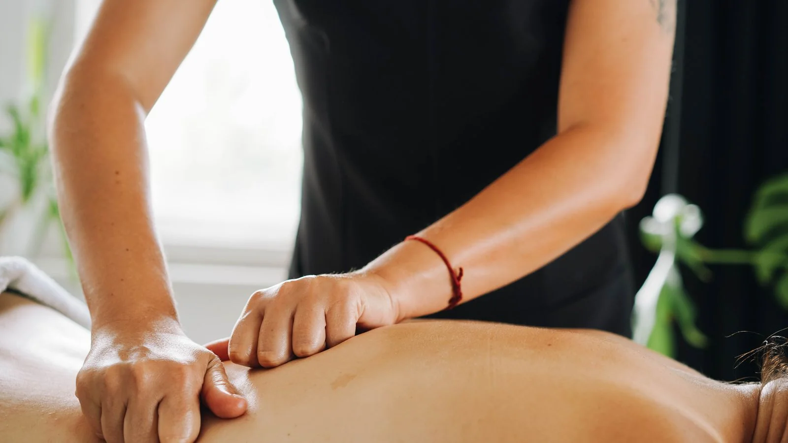 A practitioner working with focused pressure on a client, the condition-specific work most sites never describe in text