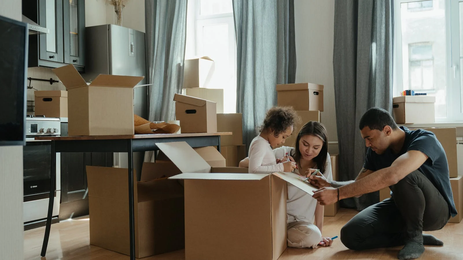 Family unpacking boxes inside a sunlit new kitchen, the moment a successful mover sells against