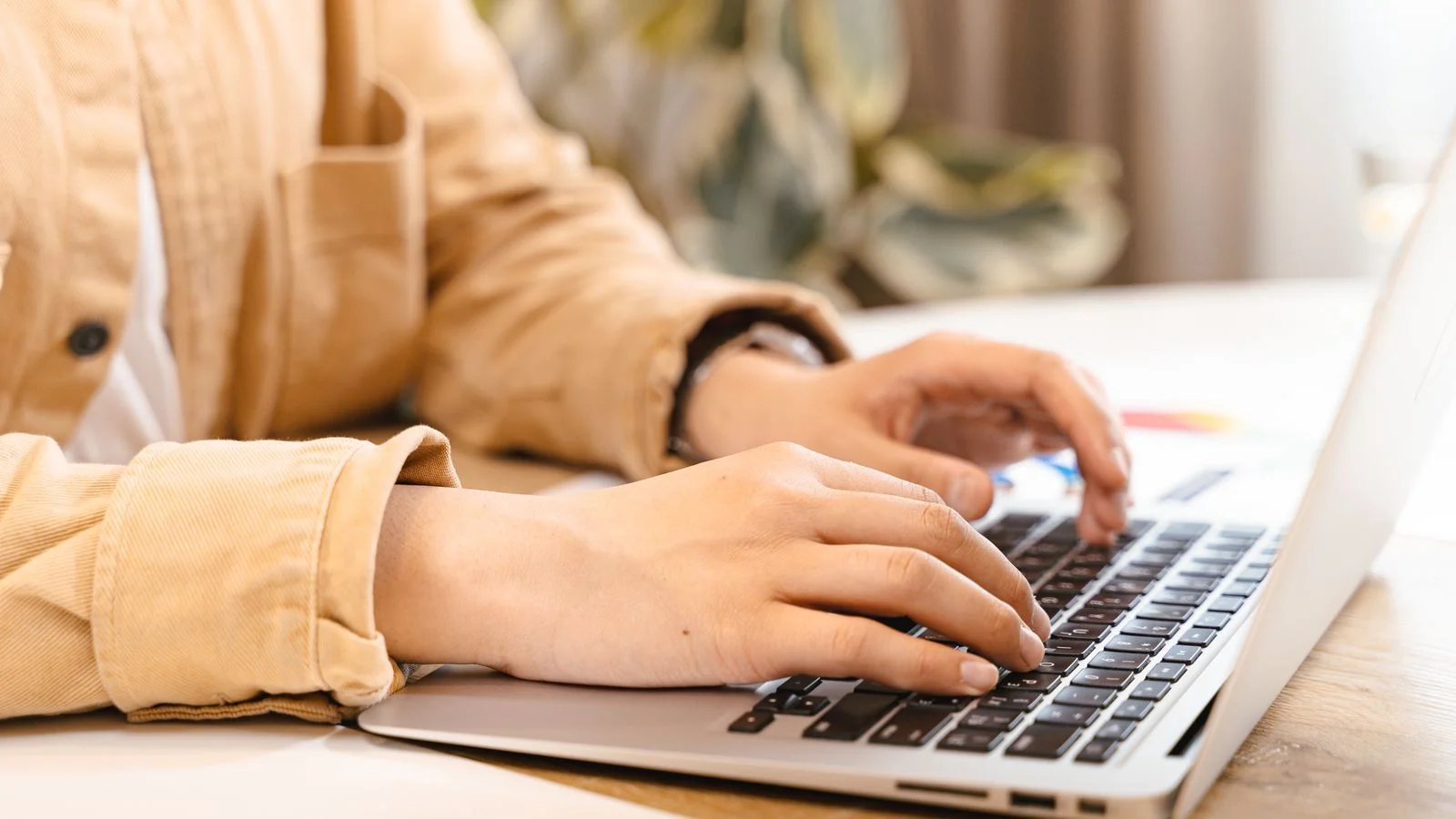 Hands typing on a laptop, drafting the category pages an answer engine can actually use