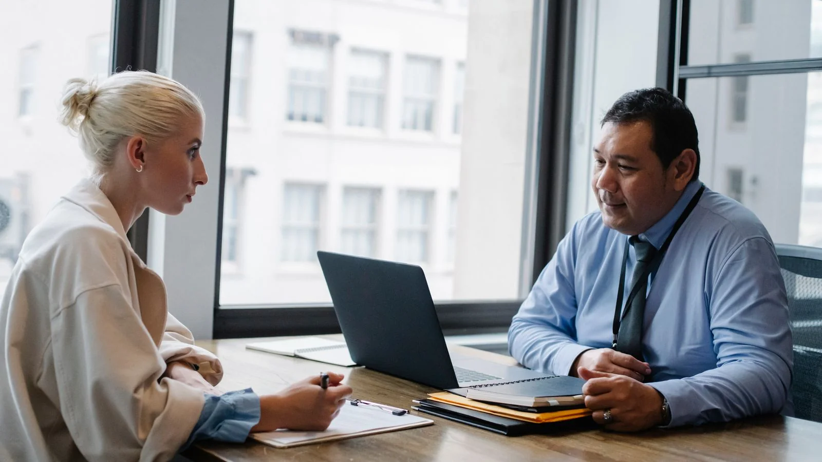 Hiring manager reviewing a candidate form with an applicant across an office desk