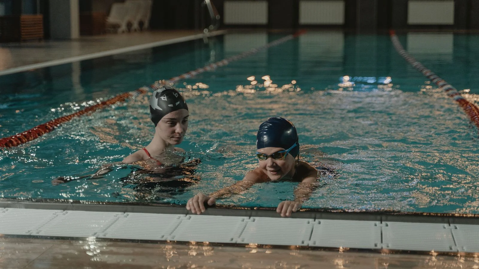 Two swimmers training in an indoor pool