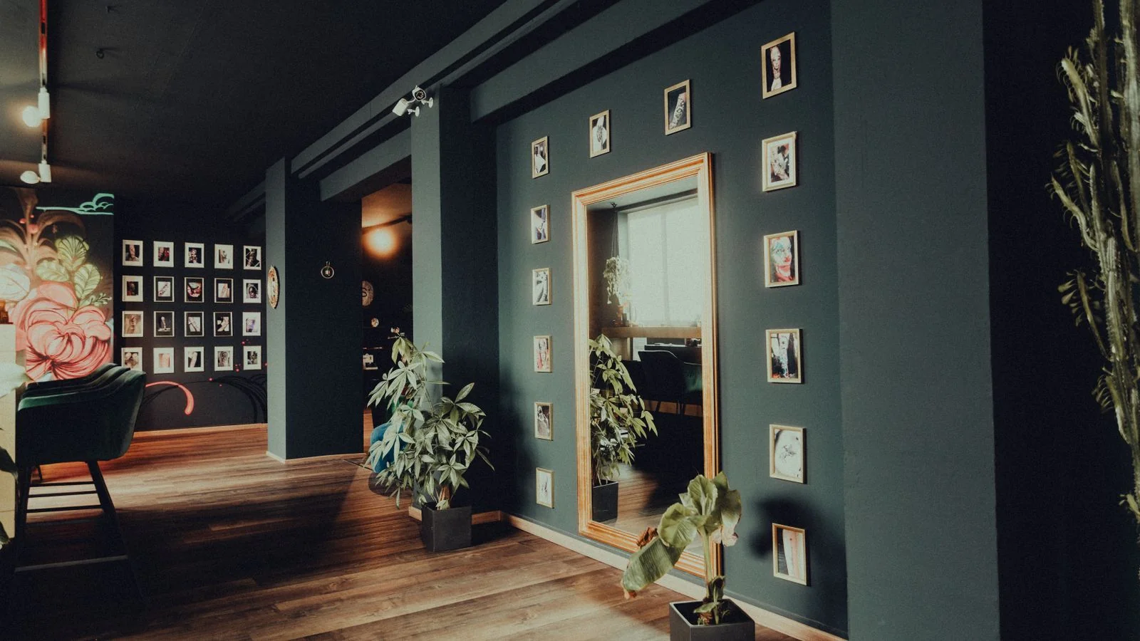The interior of a modern tattoo studio with framed artwork along the wall and clean workstations