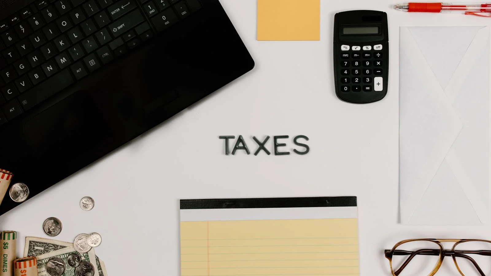 Tax documents arranged beside a computer keyboard on a desk.