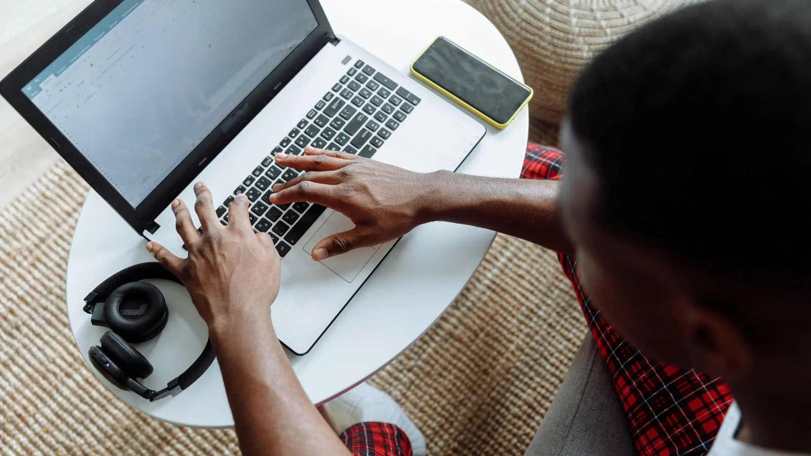 A pet owner at home types a question about their dog into a laptop