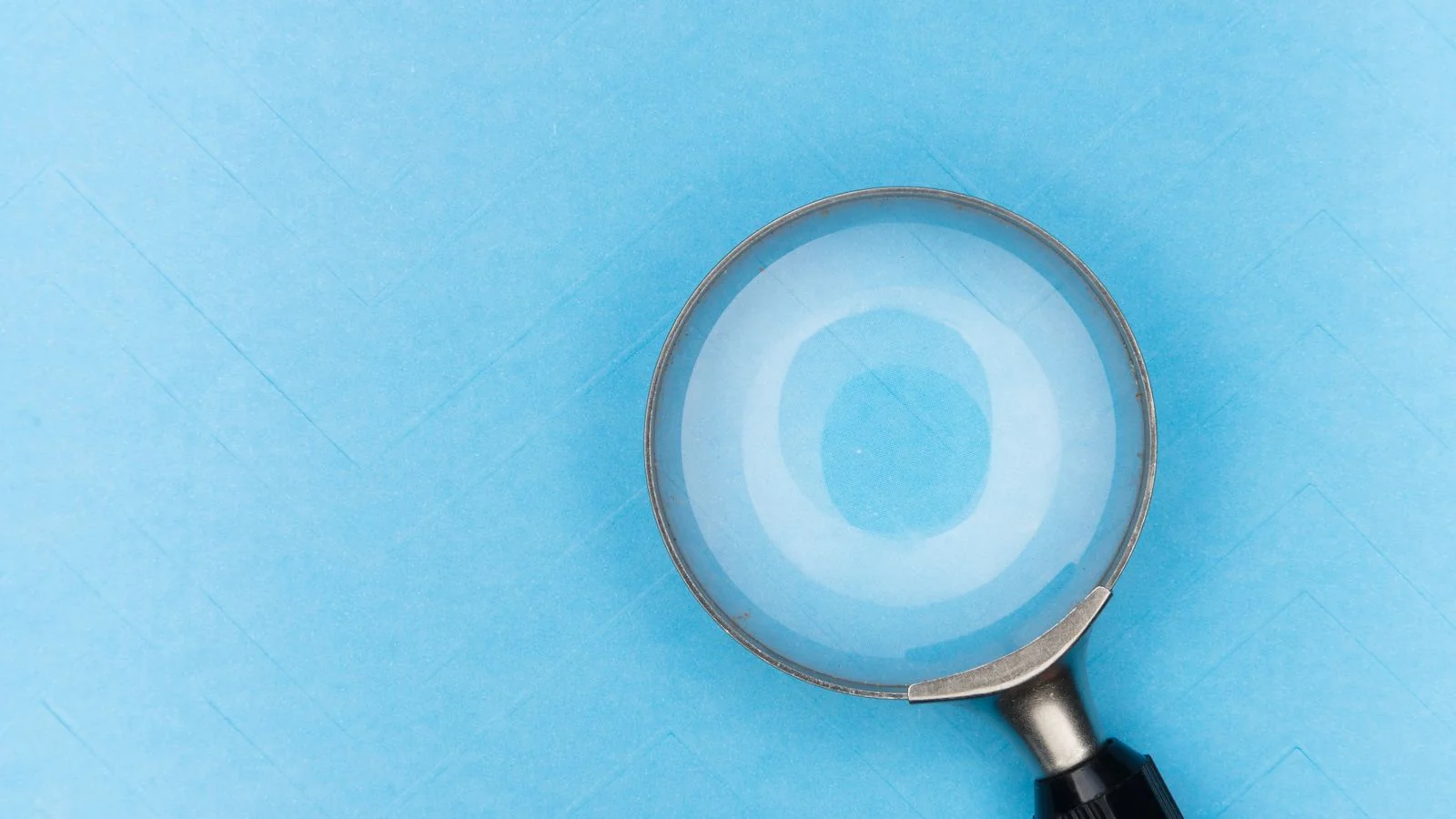 A magnifying glass on a blue surface, the passage-level focus AEO brings to a page