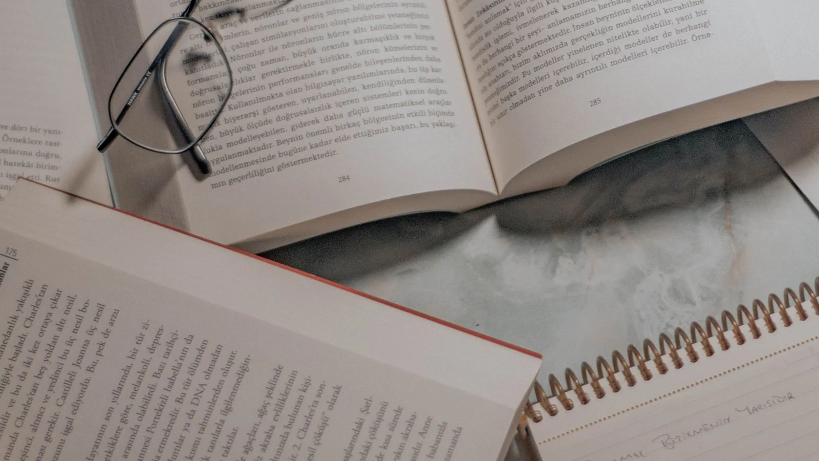 Open books and glasses on a desk, the research an engine does before it decides who to cite