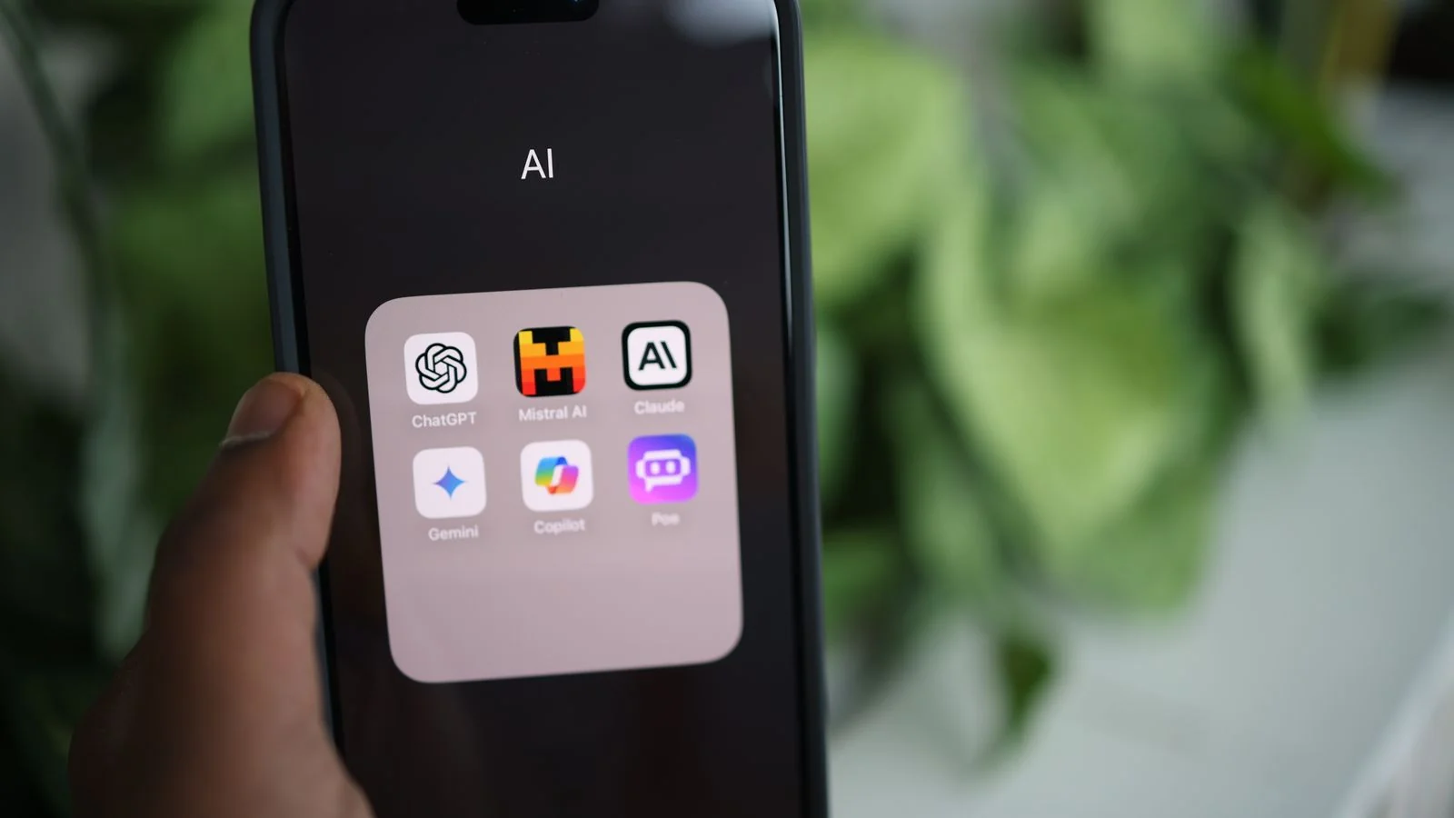 A hand holding a smartphone running AI apps, the surface where a citation reaches a real person