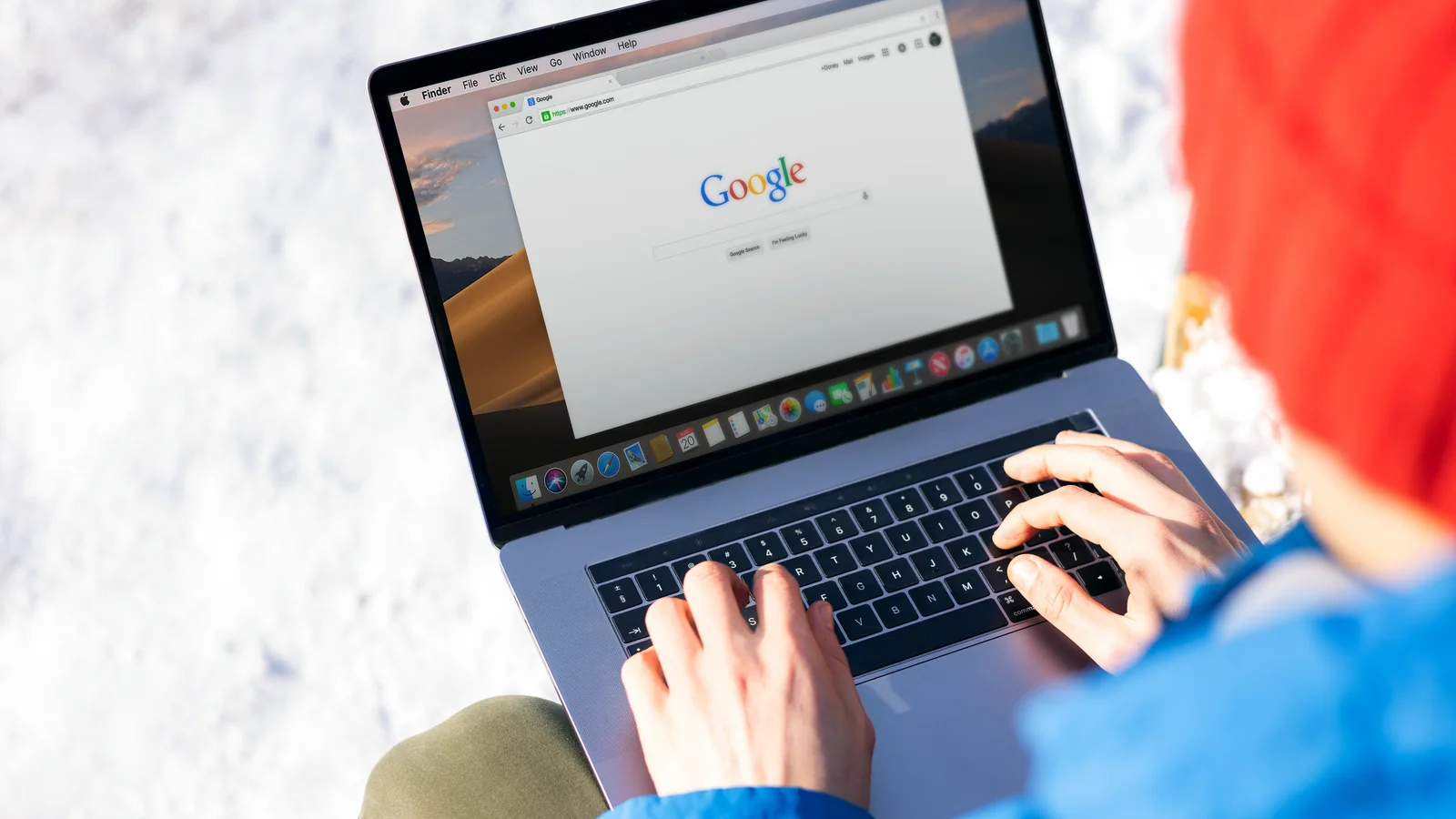 Someone typing on a laptop outdoors, publishing the clear factual content engines retrieve and ground on