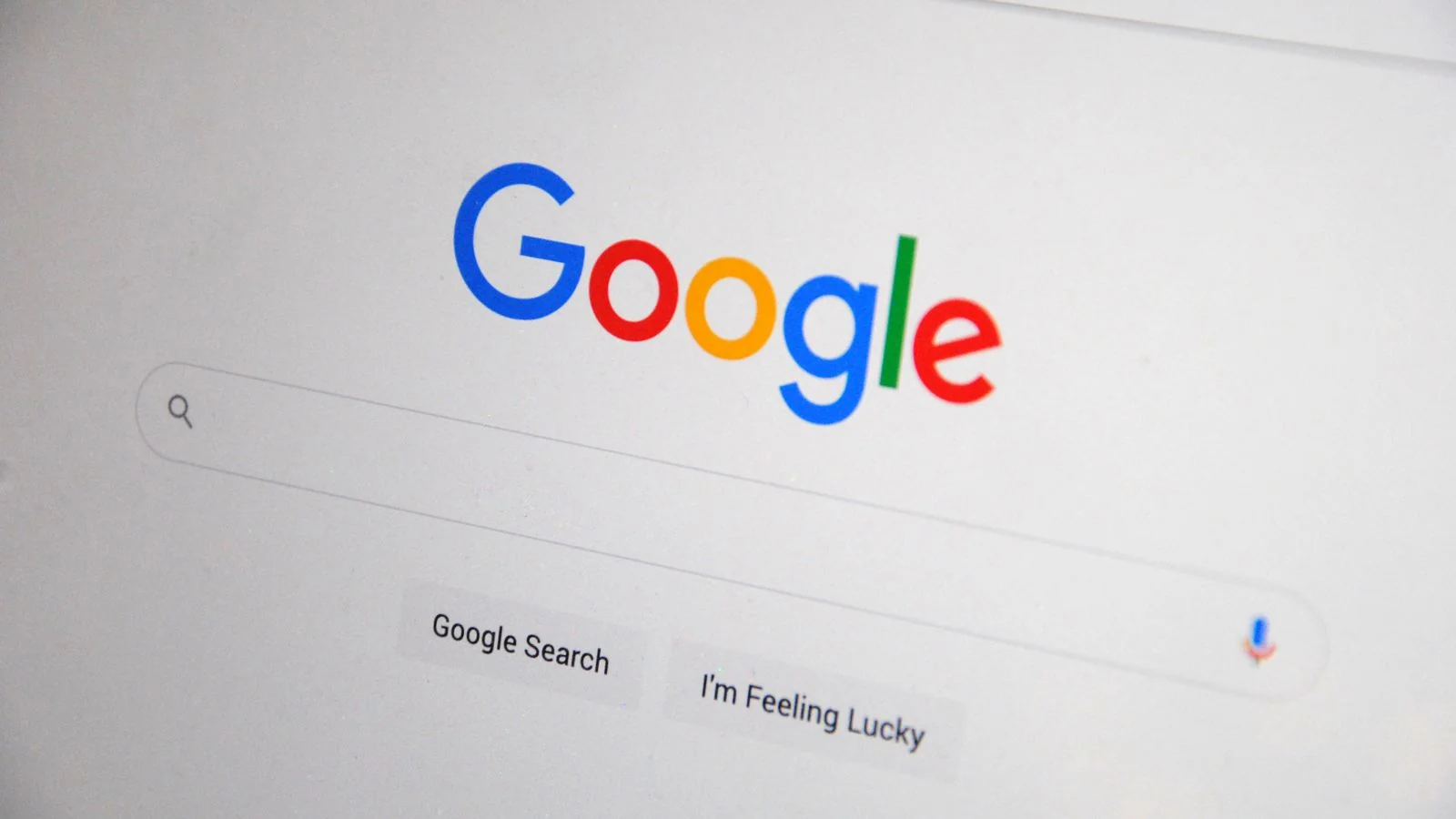 Close-up of the Google homepage on a screen, the surface where AI Overviews now intercept the answer