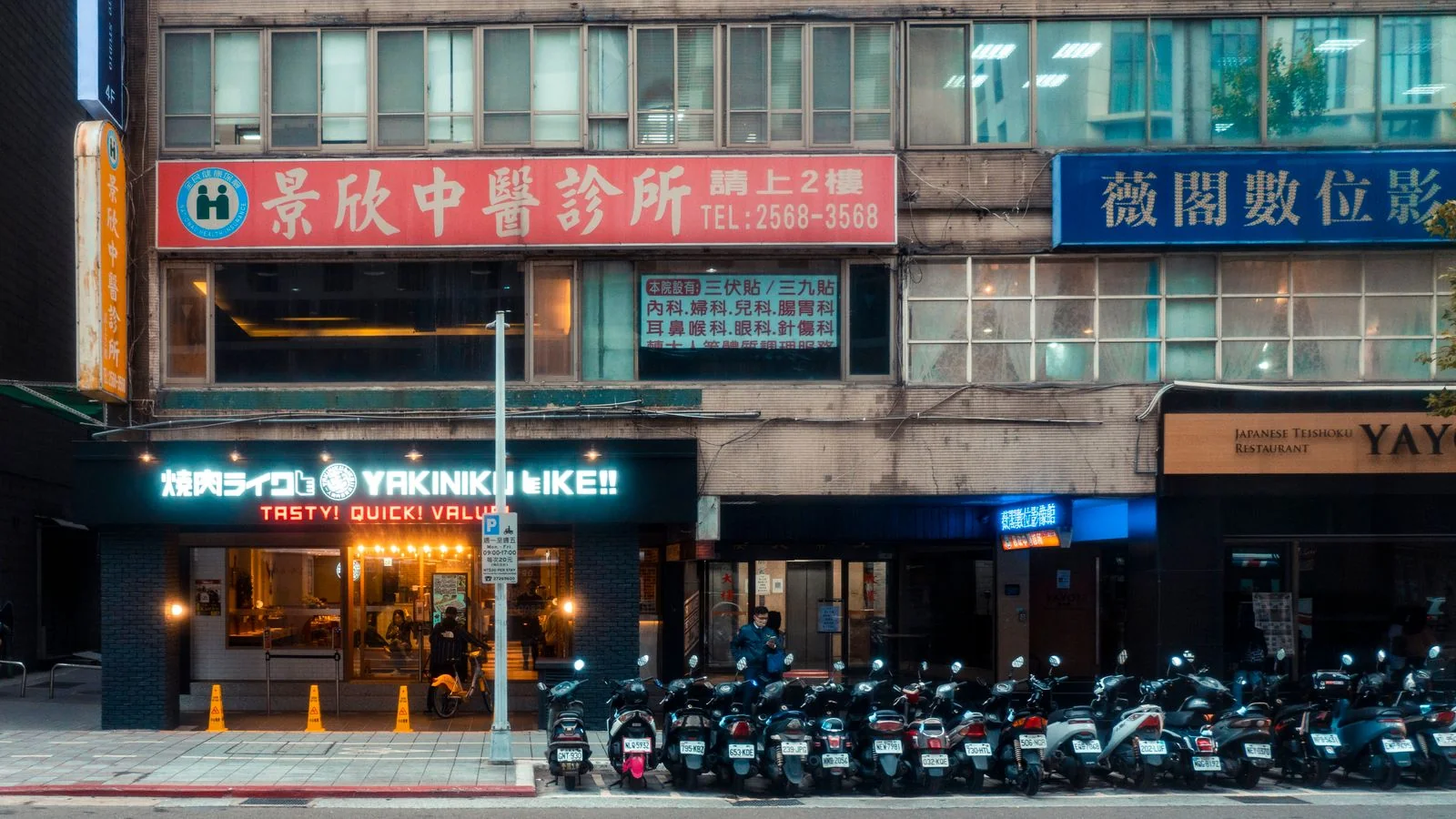 A busy urban street lined with restaurants and signage, the kind of local businesses AI now recommends