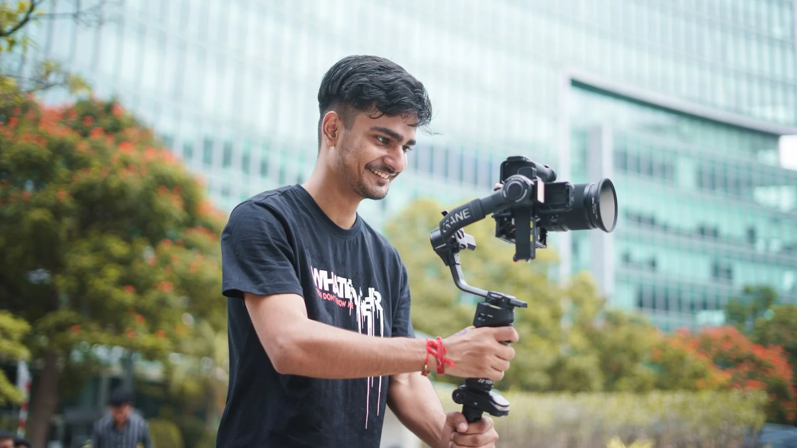 Videographer filming outdoors with a gimbal, the raw content that needs descriptive text to be found
