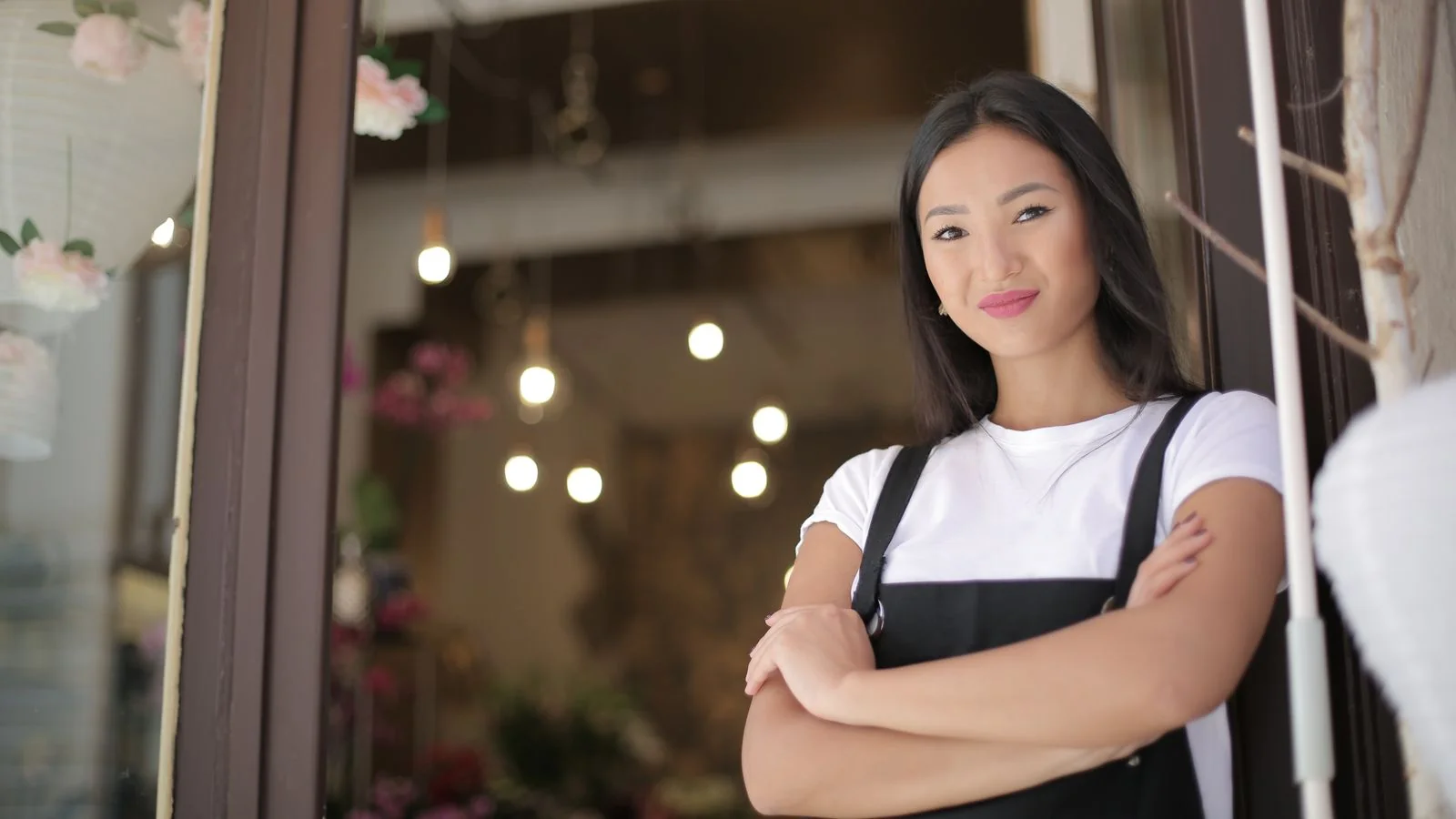 Confident florist standing at the entrance of her local flower shop