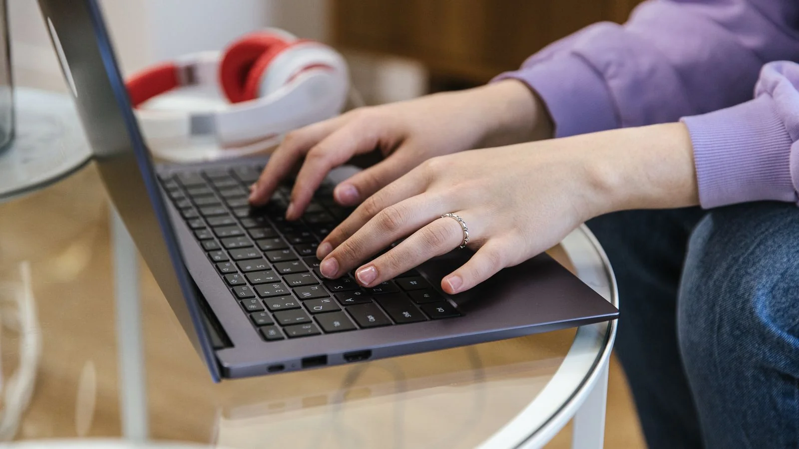 Close-up of hands typing on a laptop, drafting content that leads with the answer instead of the setup
