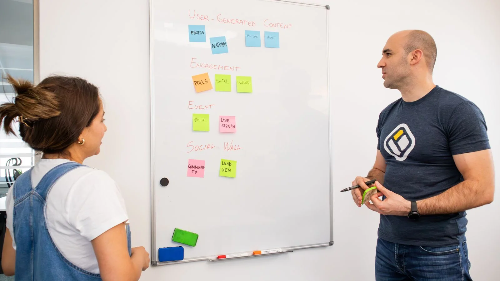 Colleagues brainstorming strategy notes on an office whiteboard