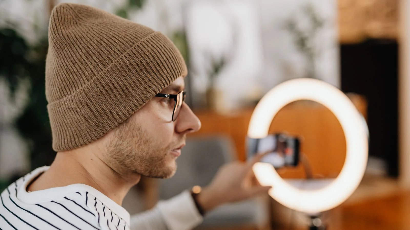 Creator recording a video at home with a smartphone and ring light to grow a newsletter audience