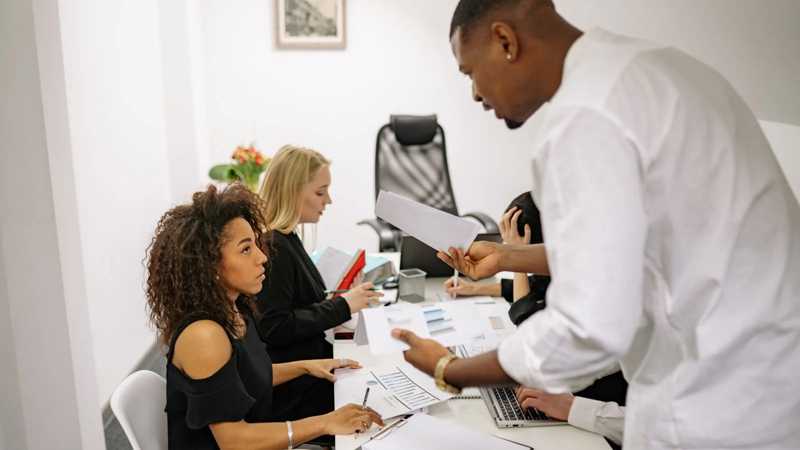 Tense office meeting where a man and woman argue over printed documents across a desk