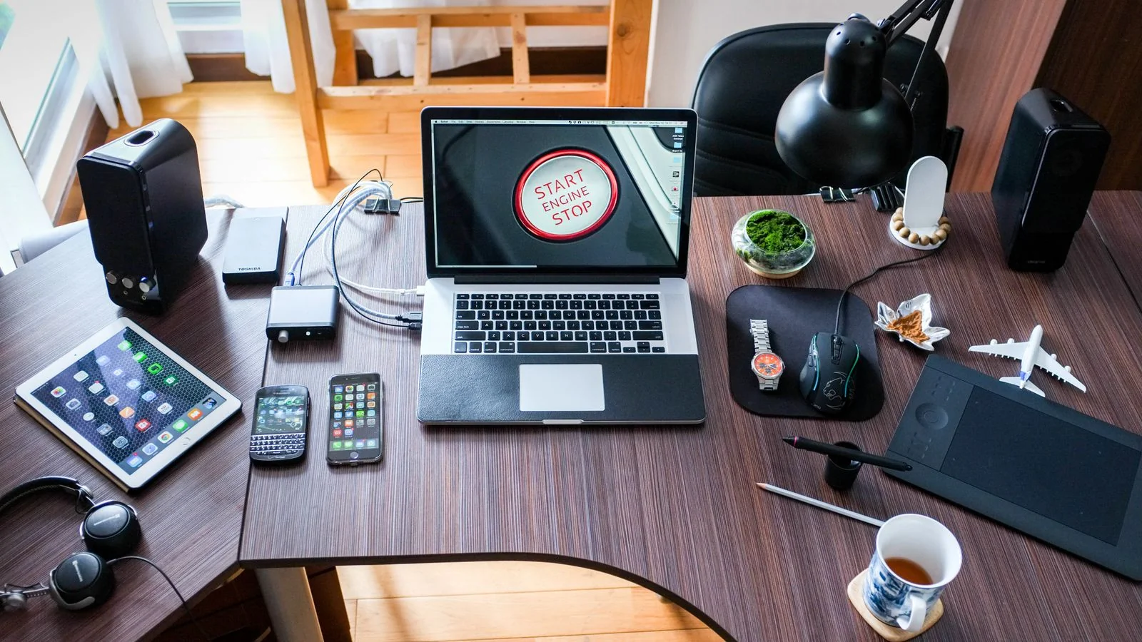 A laptop showing a live news article next to a notebook of pitch notes