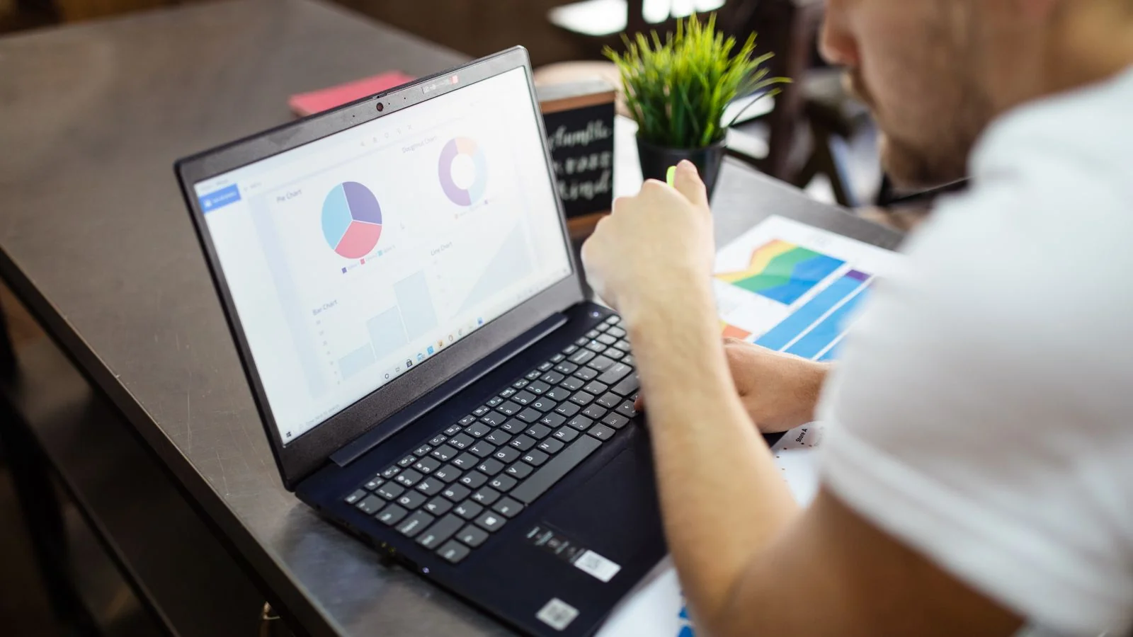 A person reviewing charts and comparison data on a laptop at a desk