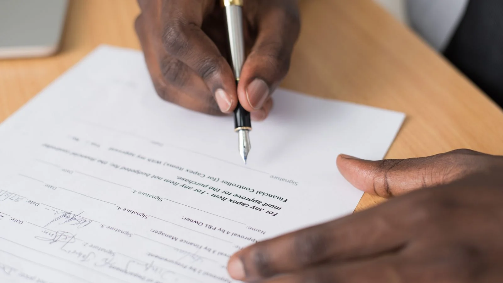 Hands signing a formal contract, the multi-year commitment that decides your real cost