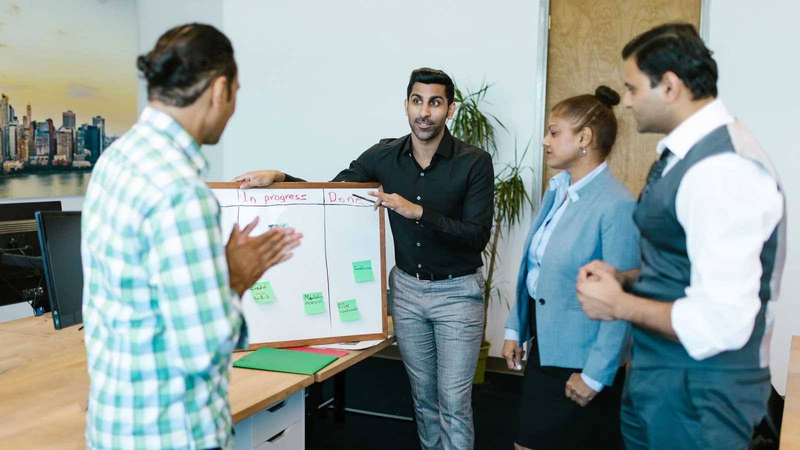 A team reviewing progress around a board in an office, the channel mix a distribution plan balances