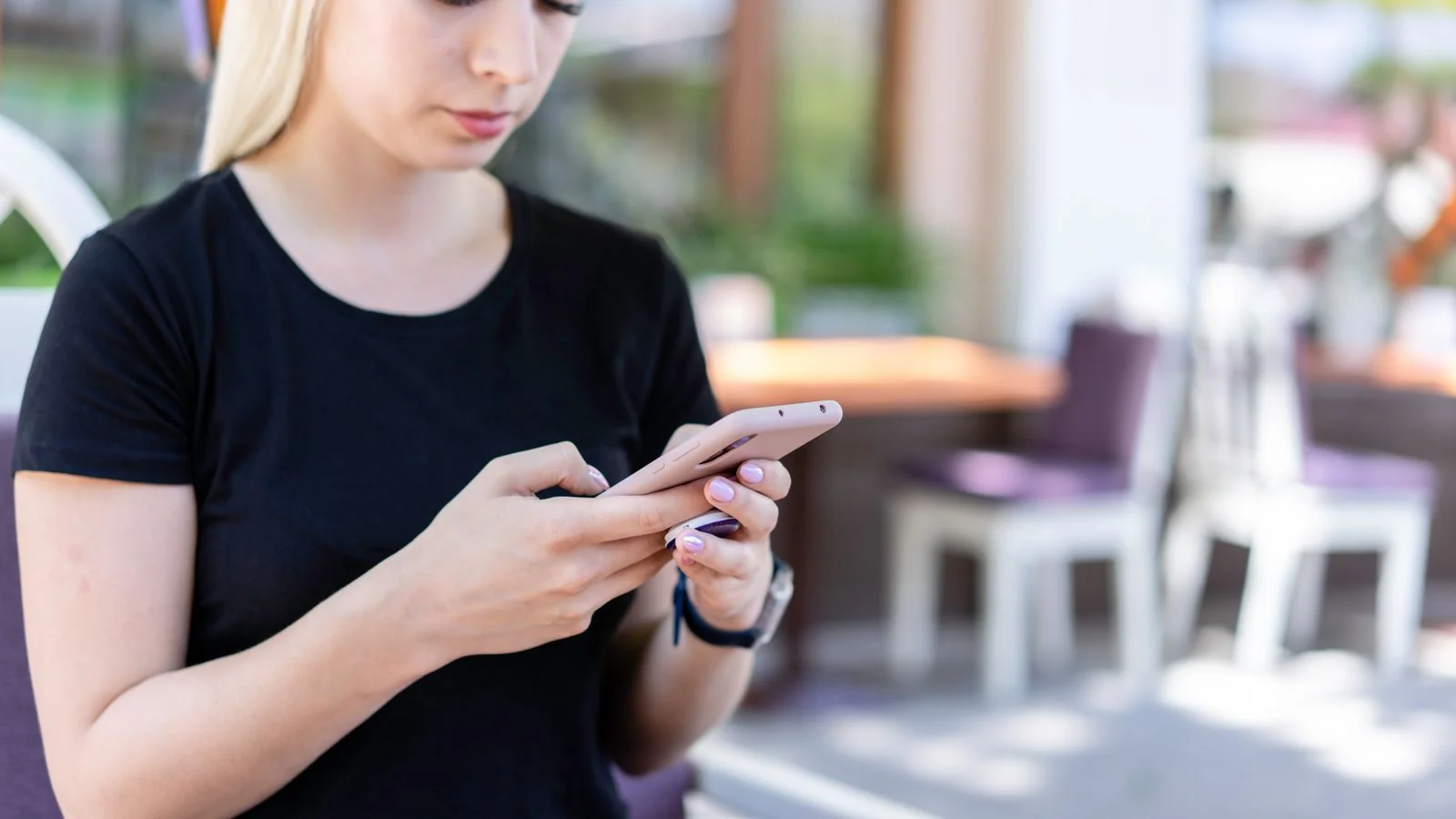 A person checking their phone while sitting in a cafe.