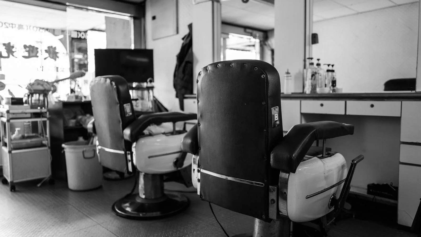 A classic barbershop interior in black and white, the room a first-time customer is trying to picture before he walks in