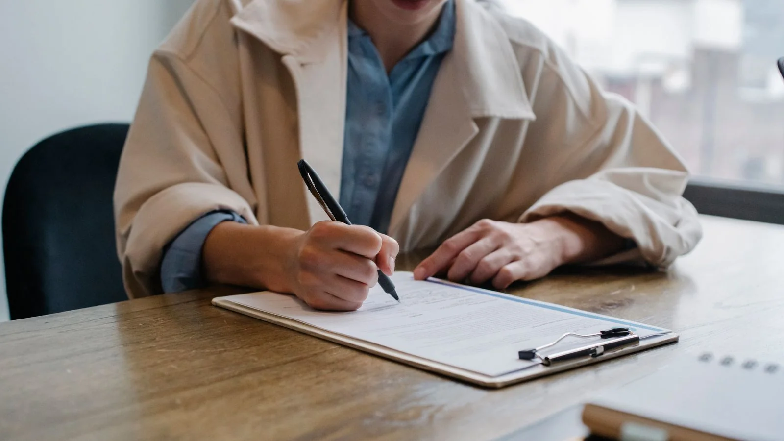 A job seeker filling in a questionnaire at an interview table