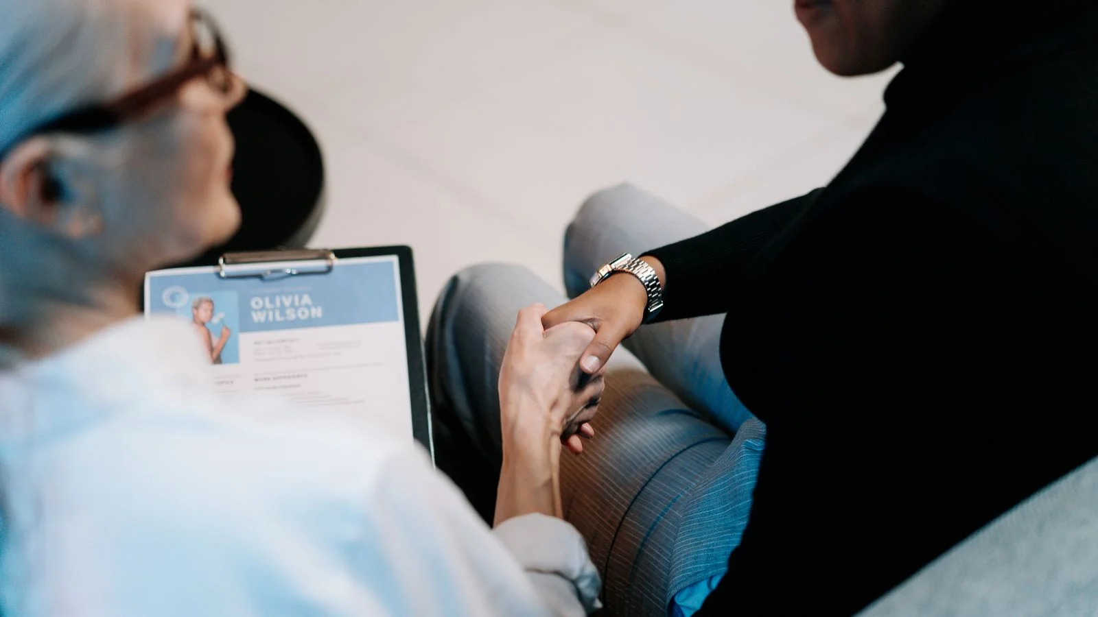 Two professionals shaking hands in an office, the moment the negotiation post is written for