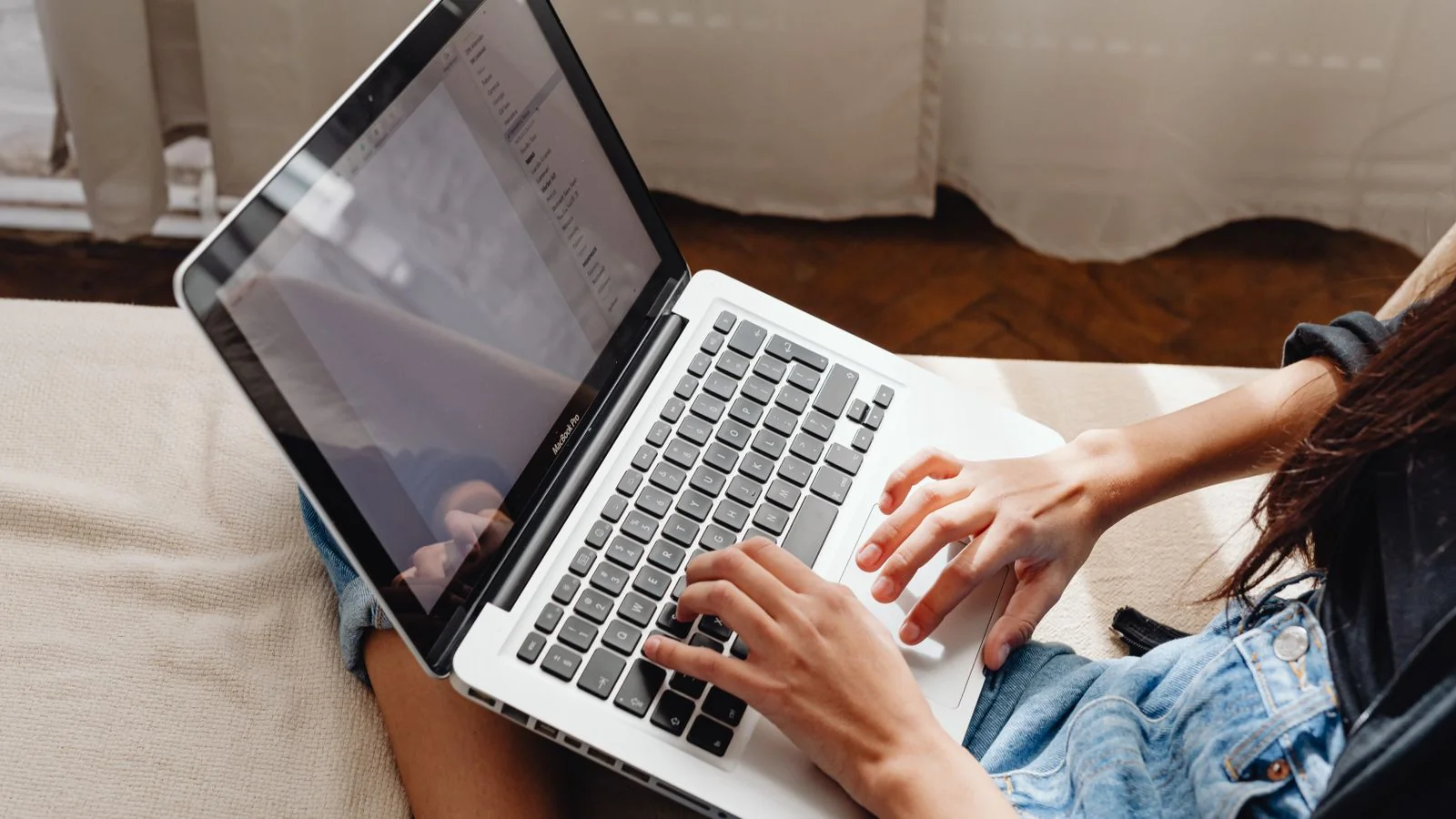 A homeowner's hands typing on a laptop, the weeks of research that happen before a concrete quote.