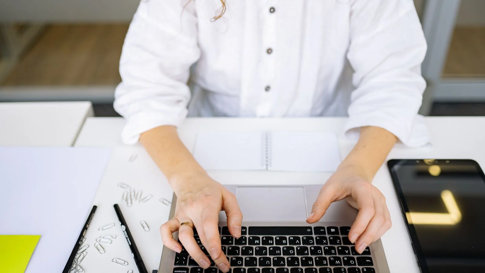 A person writing at a laptop.