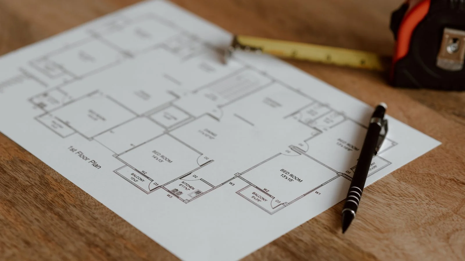 An architectural floor plan on a desk with a pen and ruler, the document planners want and almost never find on a venue site.
