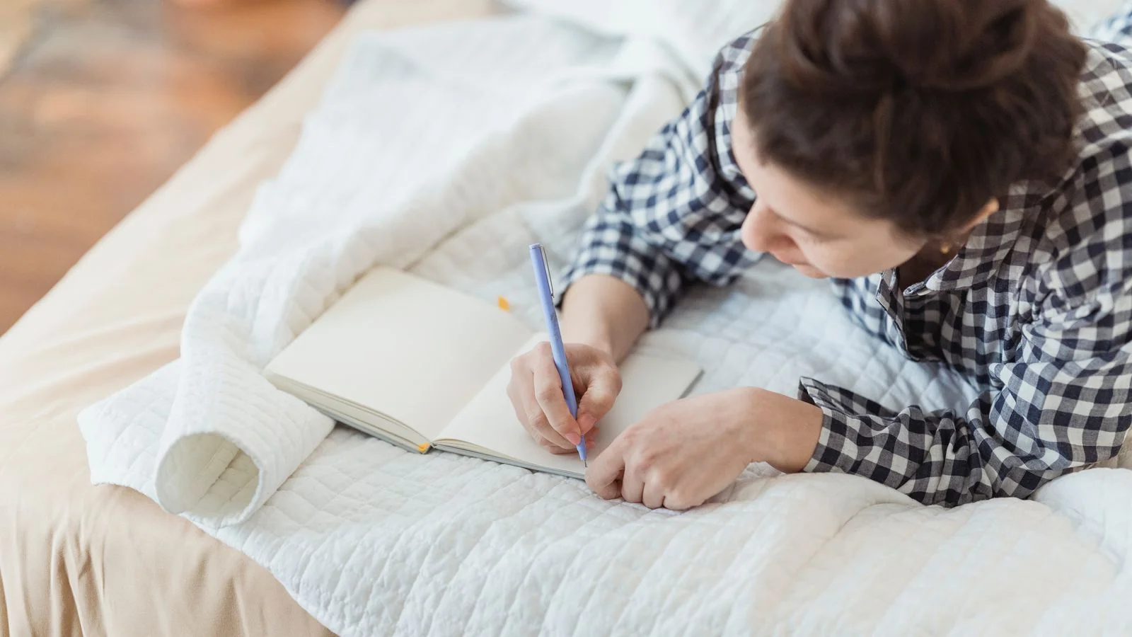 A woman writing in a journal in soft light, the post float habit that turns one session into a membership