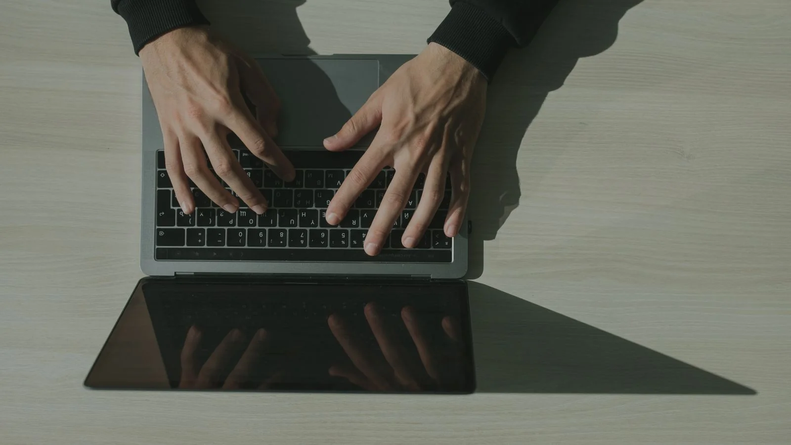 Hands typing on a laptop from overhead, the one long piece most coaches never write
