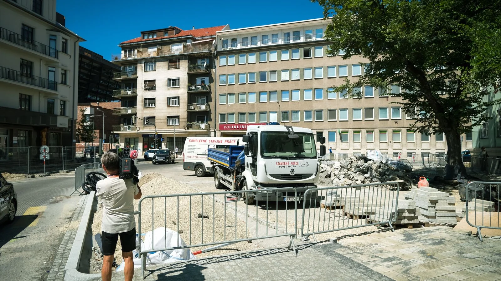 A photographer documenting a construction site, turning finished masonry into content buyers can find.